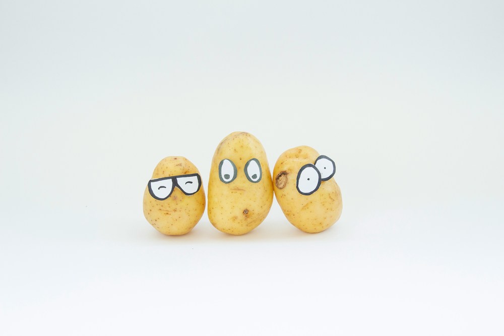 Three potatoes with faces drawn on them.