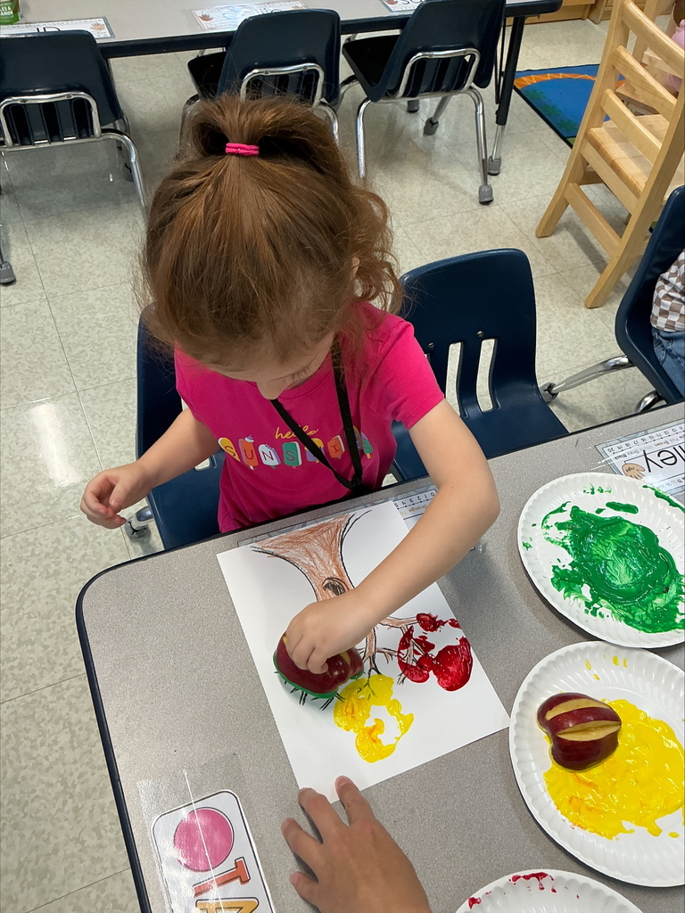 Students using apples to make apple prints
