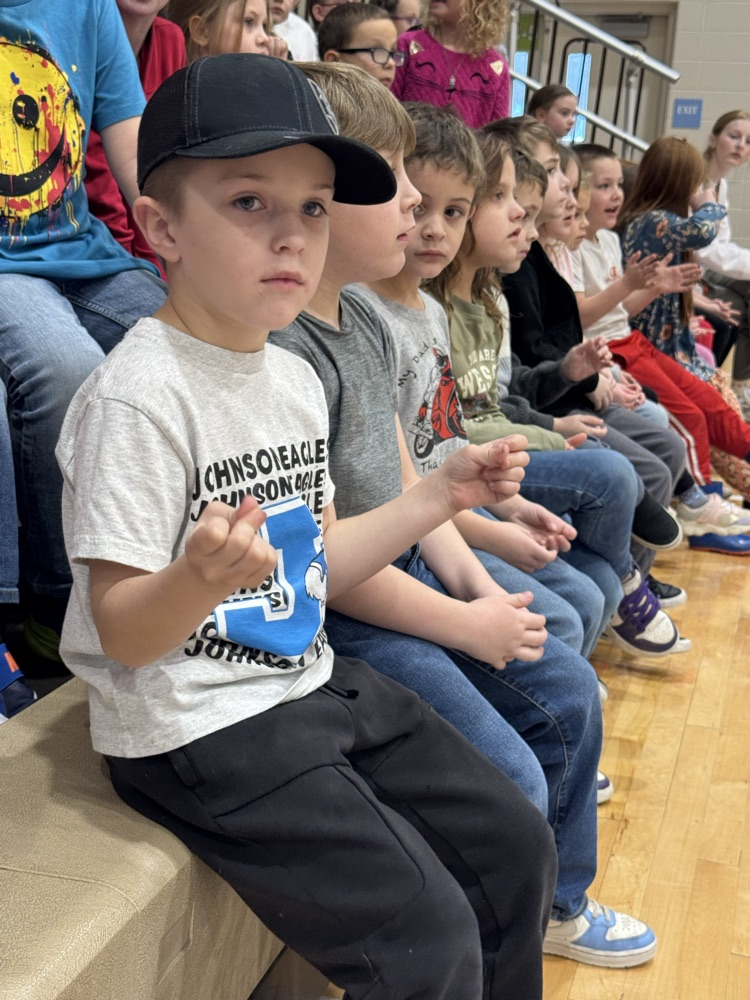 students sit in the bleachers watching the school rally.