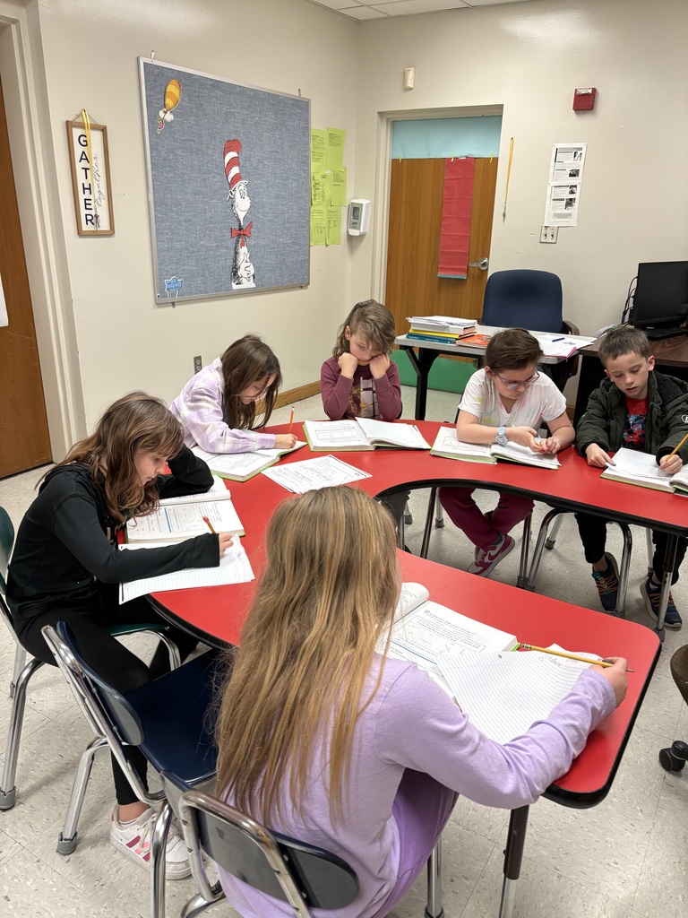 Students sitting around table working on Reading Mastery activity