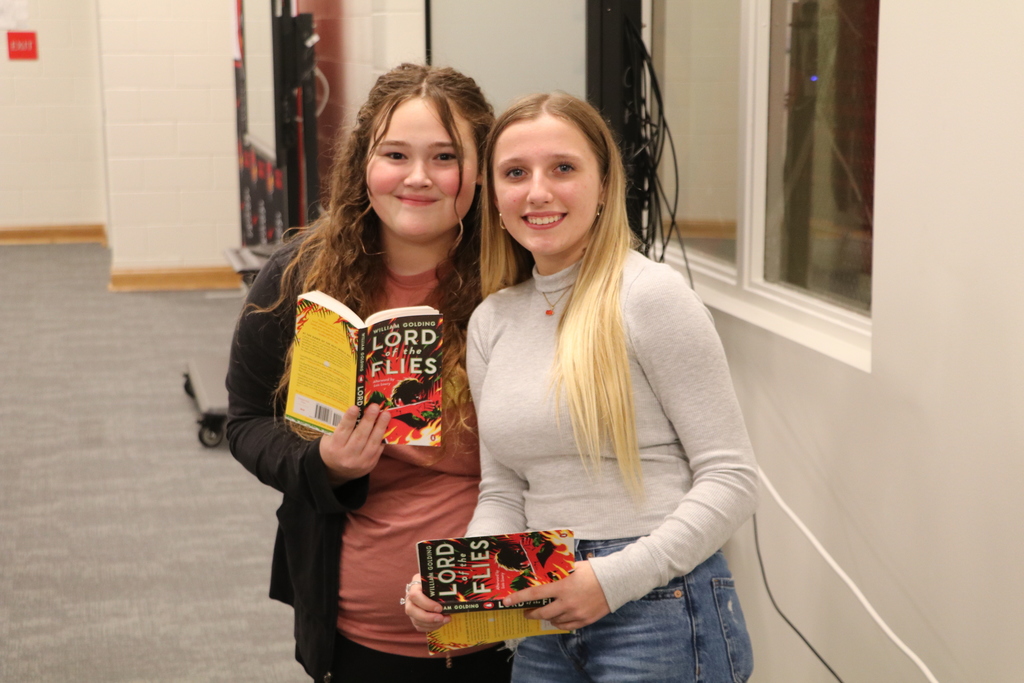 Two High School students smiling and posing with copies of Lord of the Flies