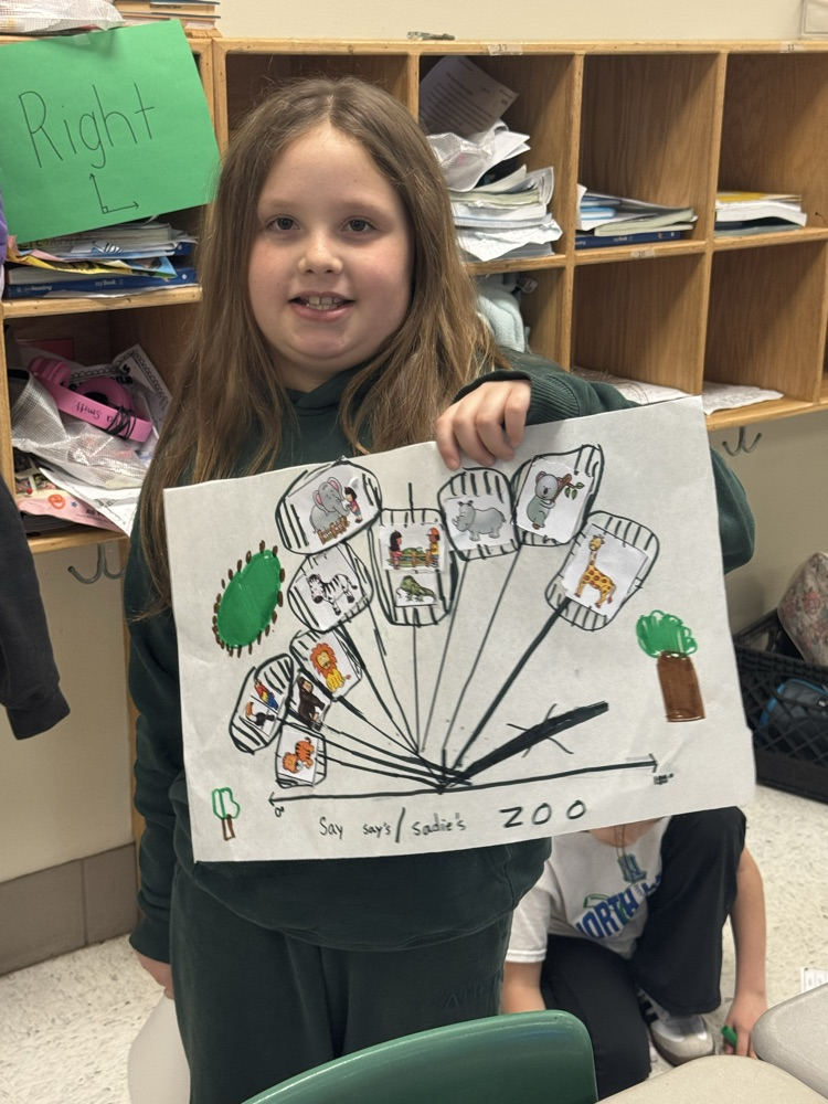 A girl holds up her completed angle project.
