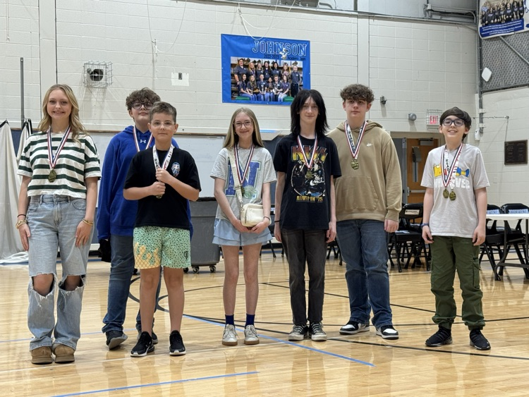 Students stand in line in the Johnson Elementary gym with certificates and medals celebrating their 2025 KSA test scores. 