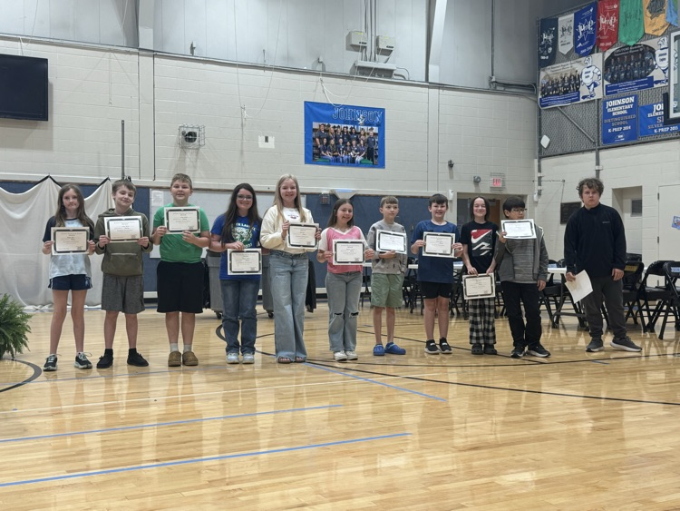 Students stand in line in the Johnson Elementary gym with certificates and medals celebrating their 2025 KSA test scores. 