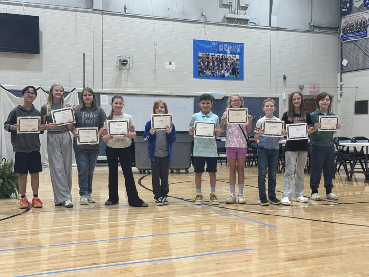 Students stand in line in the Johnson Elementary gym with certificates and medals celebrating their 2025 KSA test scores. 