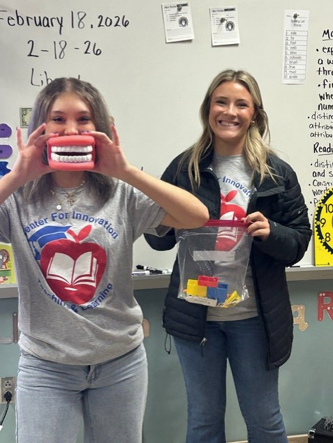 Two CFI students posing with dental props