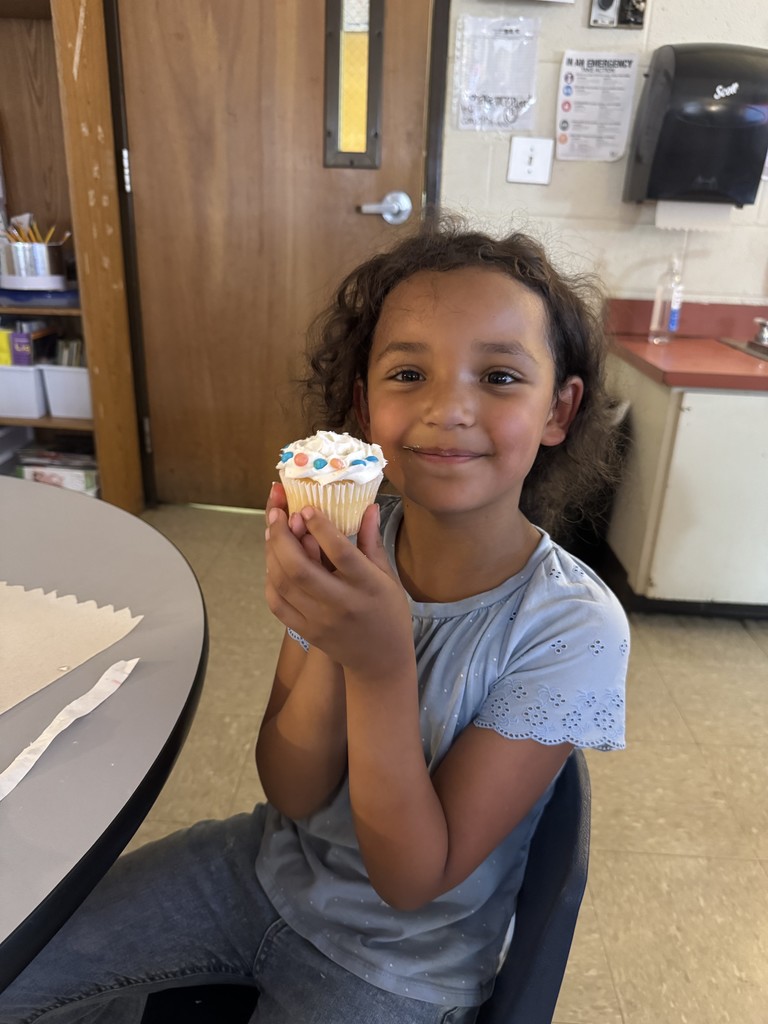 A little girl holding a cupcake