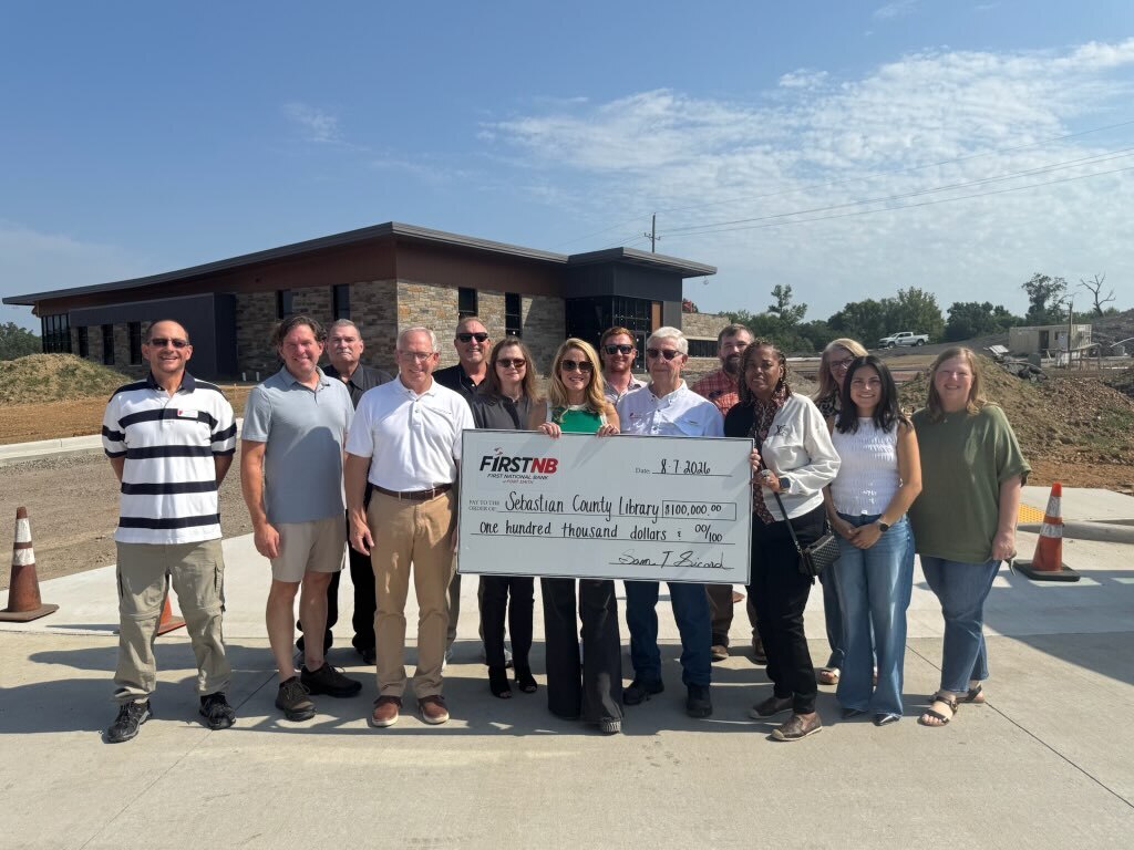 Local School District representatives standing in front of a school bus, to honor the donation of FNB to the New Library