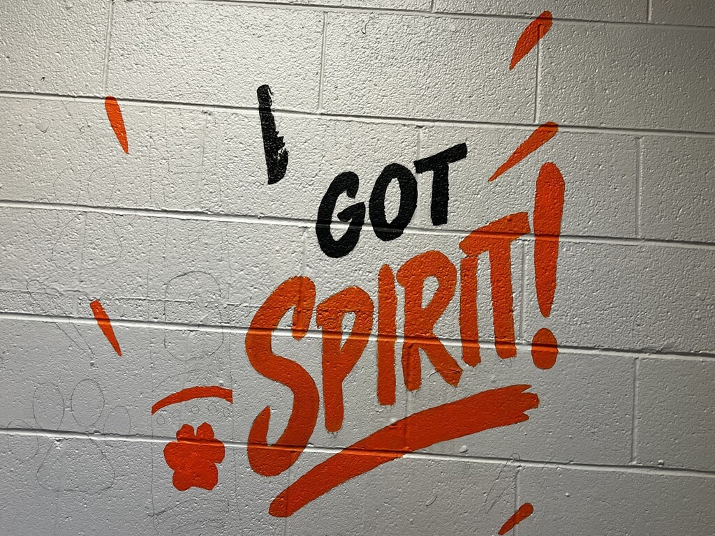 White brick wall with orange text reading "I GOT SPIRIT!" and an orange exclamation point.