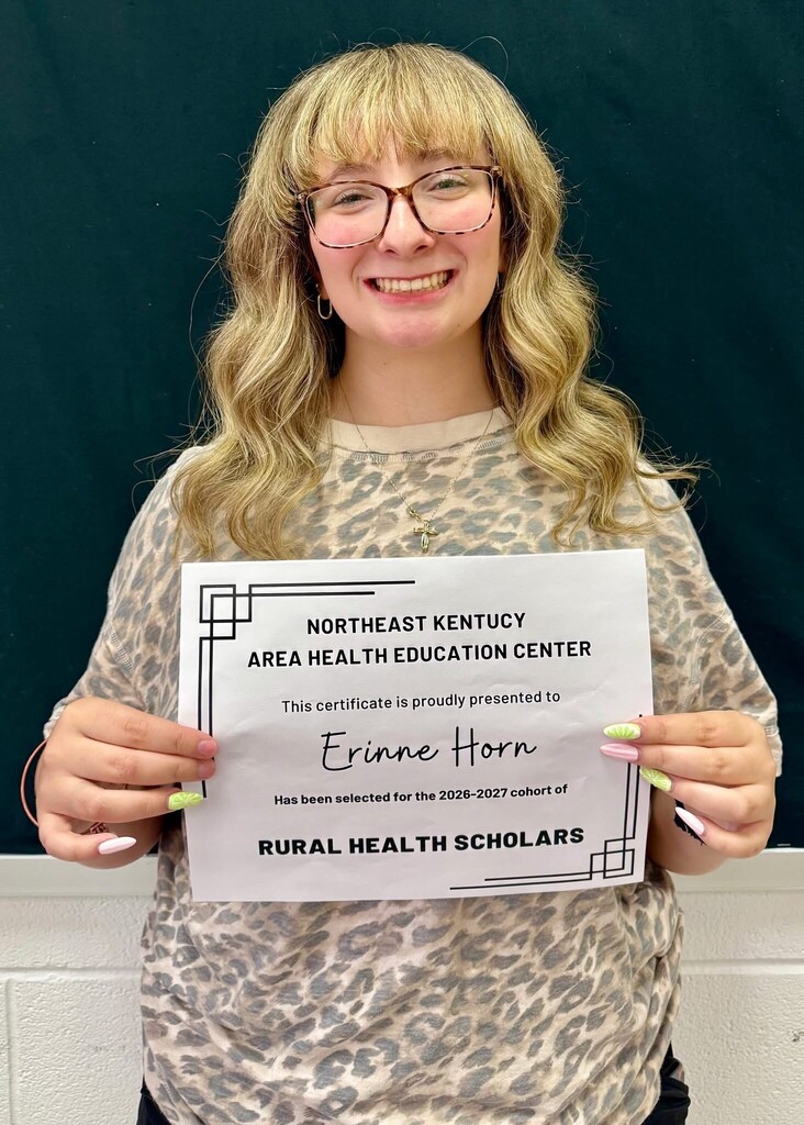 Woman with blonde hair holds up certificate. Paper reads "NORTHEAST KENTUCKY AREA HEALTH EDUCATION CENTER" and "Erin Horn" with a signature.