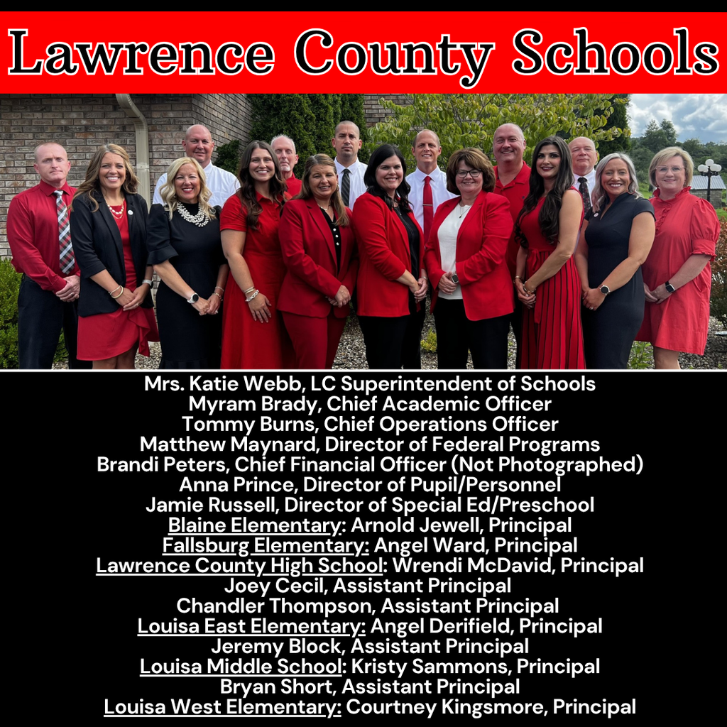A group of people in red jackets and formal attire stands in front of a building.