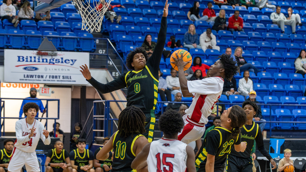 Lawton High School basketball player goes to the rim against MacArthur players at Great Plains Invitational