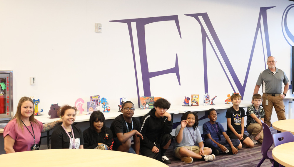 Students with their book characters designed from wood