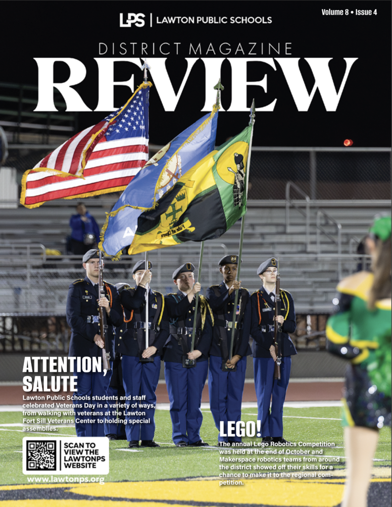 Cover of Review Magazine, featuring a group of uniformed cadets holding flags, a cheerleader, and a QR code.