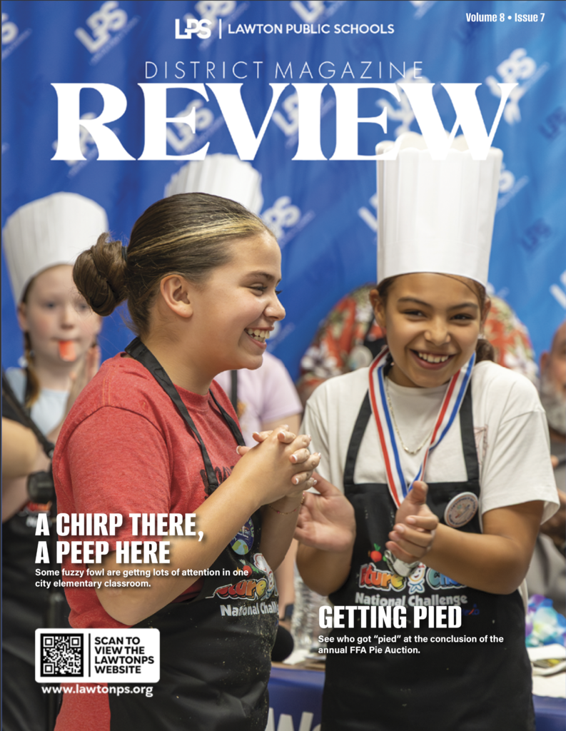 Magazine cover features two girls smiling and holding hands. One wears a chef's hat, the other a medal.