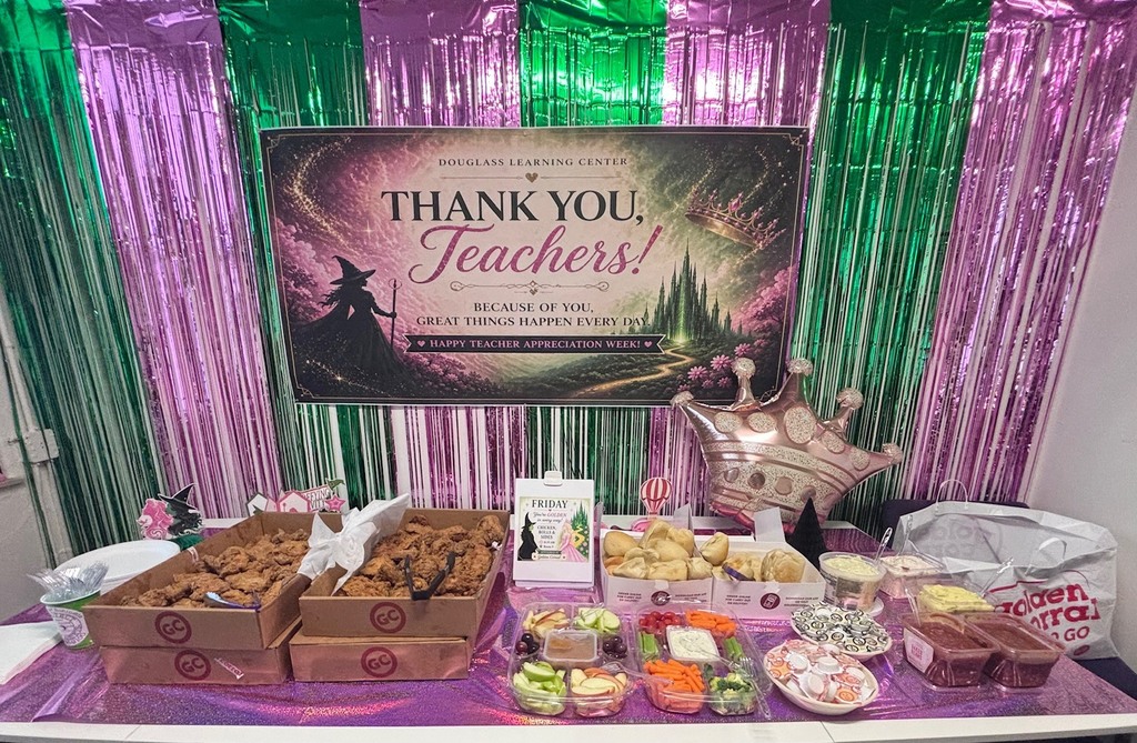Display table with food and treats. A banner reading "Thank You, Teachers!" above. Background features purple and green streamers.