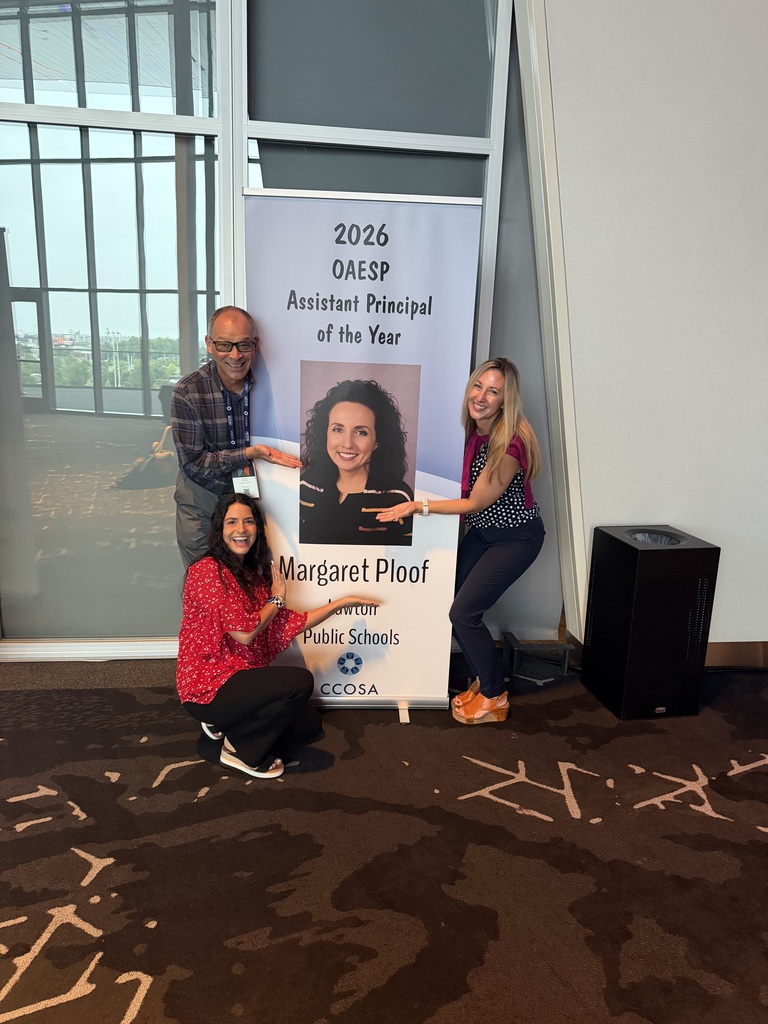 Group of educators in front of a sign.