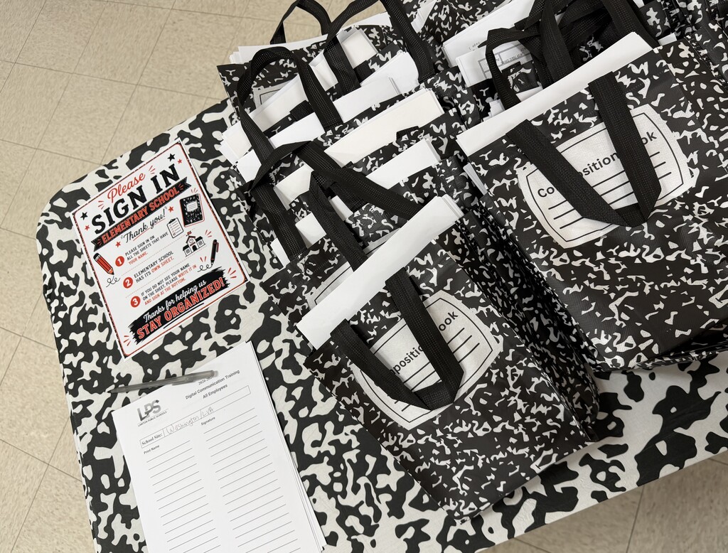 Bags with black handles stacked on a patterned surface. A sign reads "SIGN IN" with a small checklist.