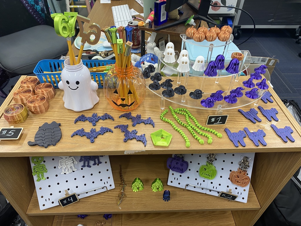 A wooden shelf has Halloween-themed items. It includes Halloween decorations, Halloween cookies, and Halloween candy.