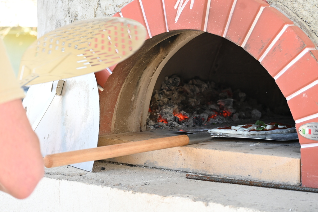 Pizza gets placed into the pizza oven at LHS