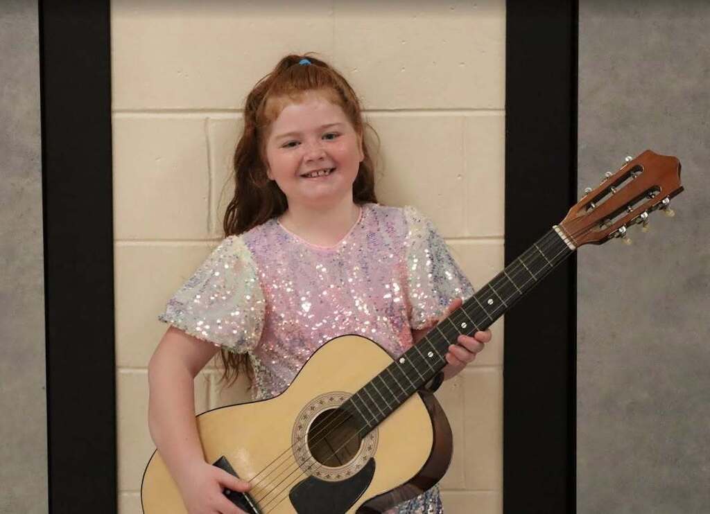 Student holding a guitar