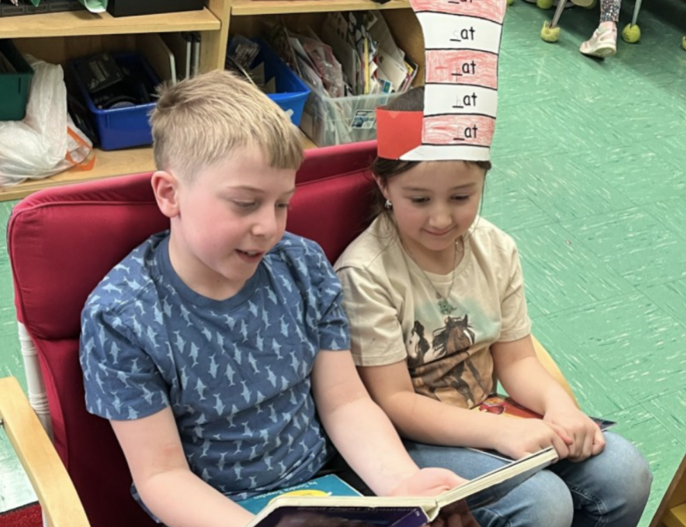 Two elementary students reading together.