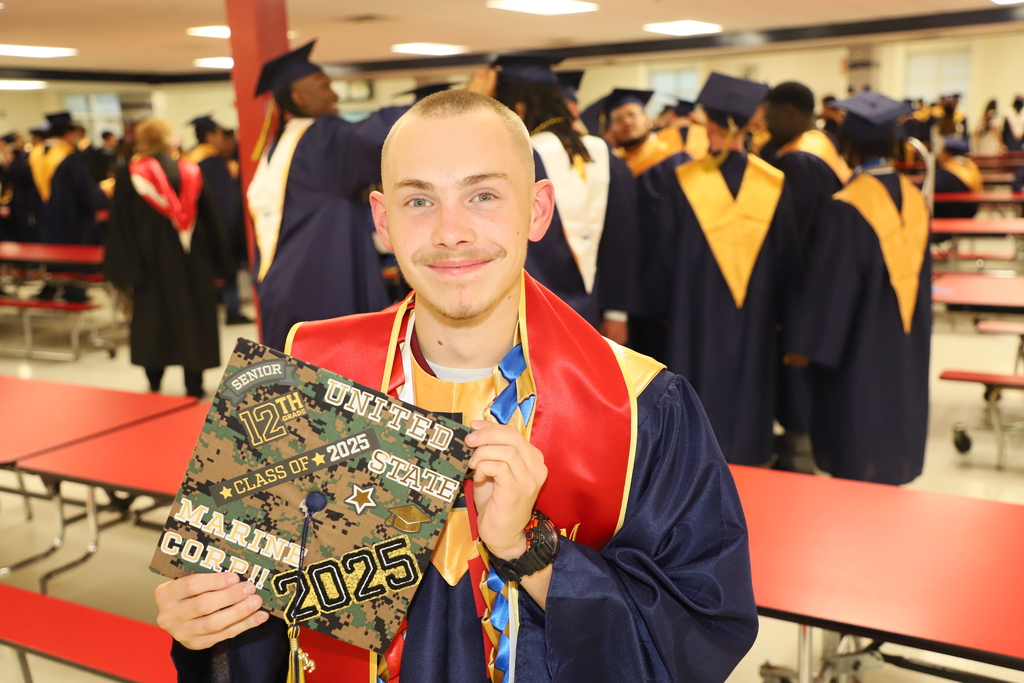 Christopher Younger poses with his cap dedicated to his career in the US Marine Corp as he graduates Lee County High School in 2025