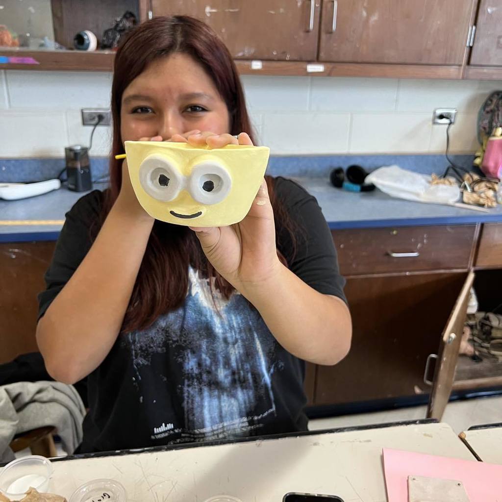 Student shows their work in ceramics class.