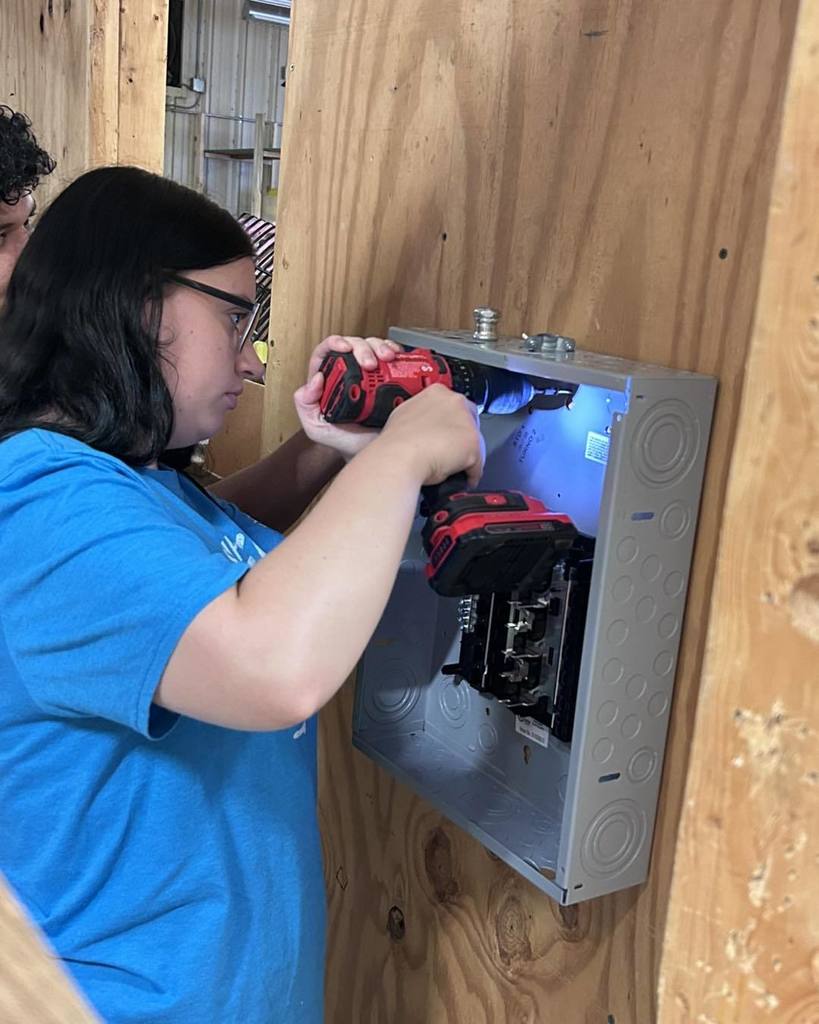 Student working to install electrical box in CTE Class