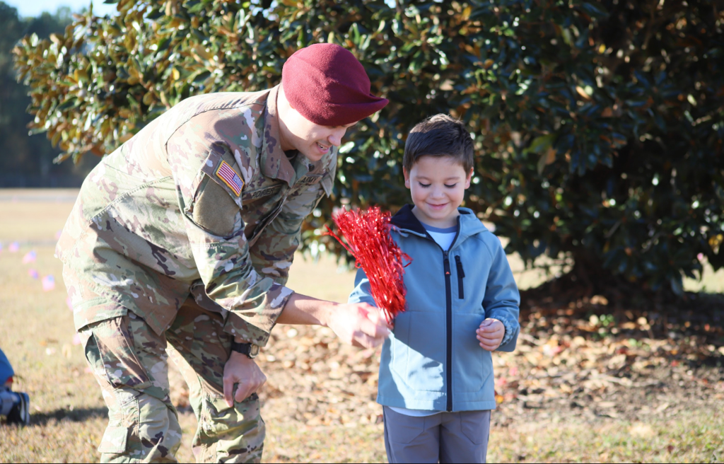 JGE Veterans Day parade student and soldier wave a pompom