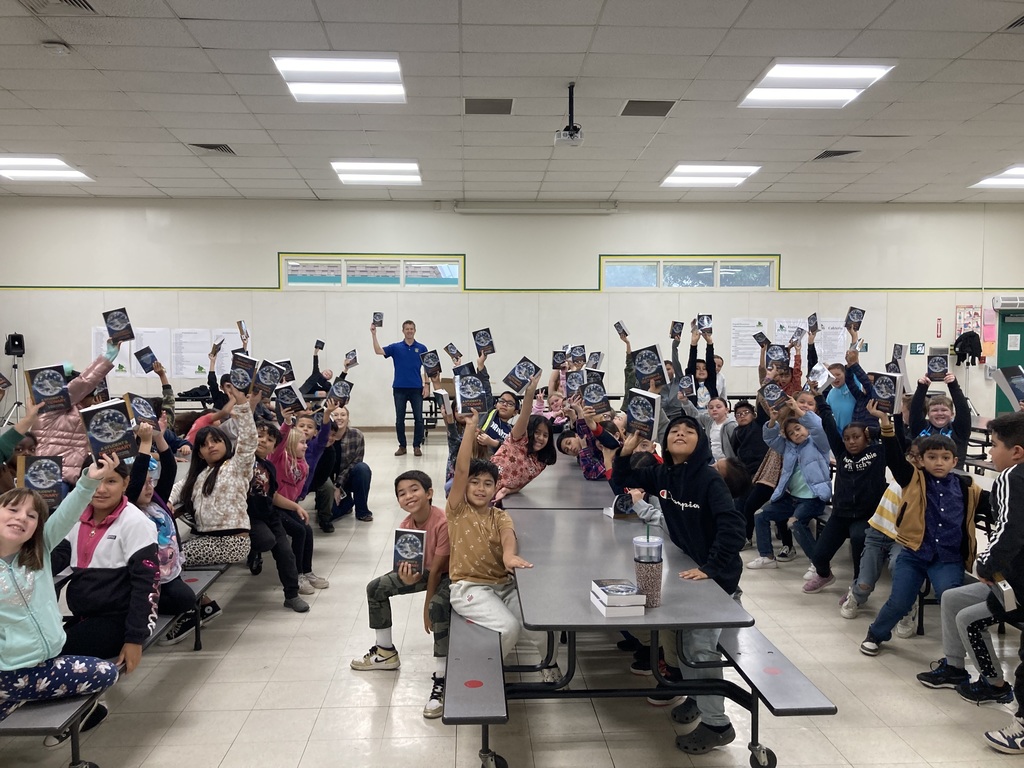 Third grade students holding up dictionaries donated by Lemoore Rotary