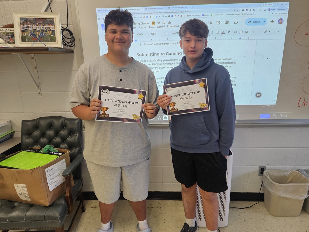 Two boys holding awards for video game design