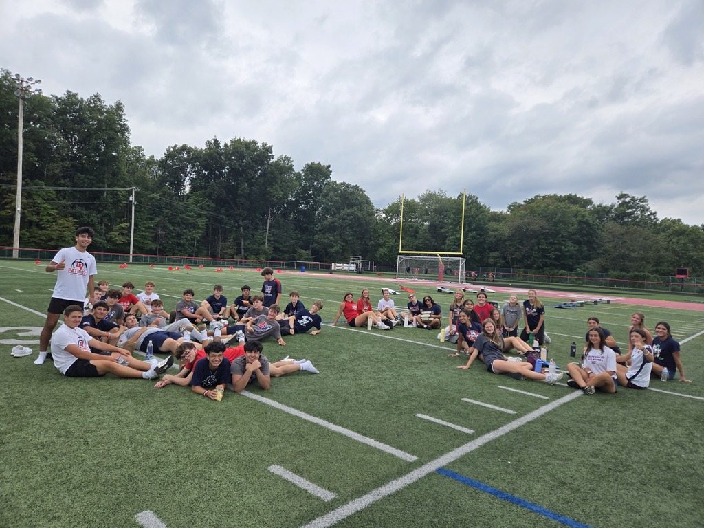 Five Lenape Valley Regional High School students smile for a photo while sitting together on the football field during Future Patriot Day.