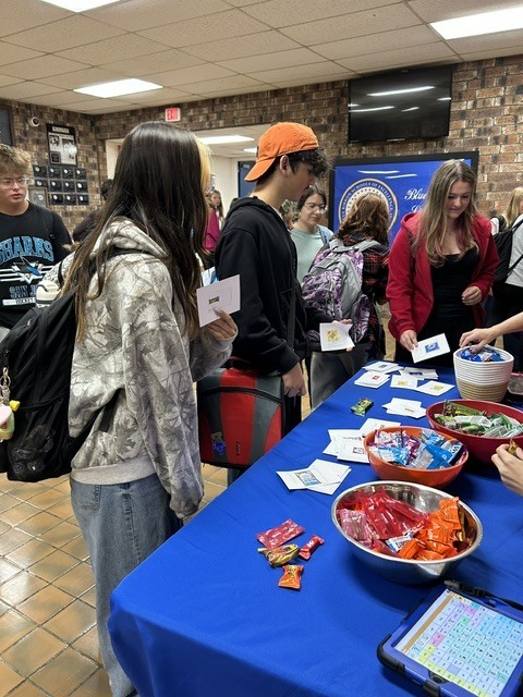Students browse printed cards and bowls of candy at the student-run Snacks and Laughs stand in the commons.