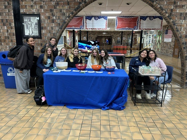 Students and staff smile behind the blue-covered Snacks and Laughs table during Lenape Valley’s Week of Respect.