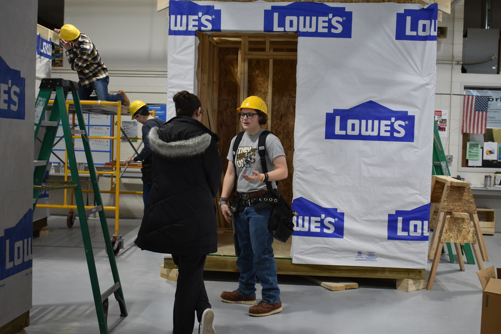 Building Trades student demonstrating for a visitor