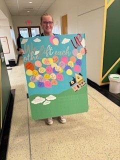 A student posing with their artwork for the event