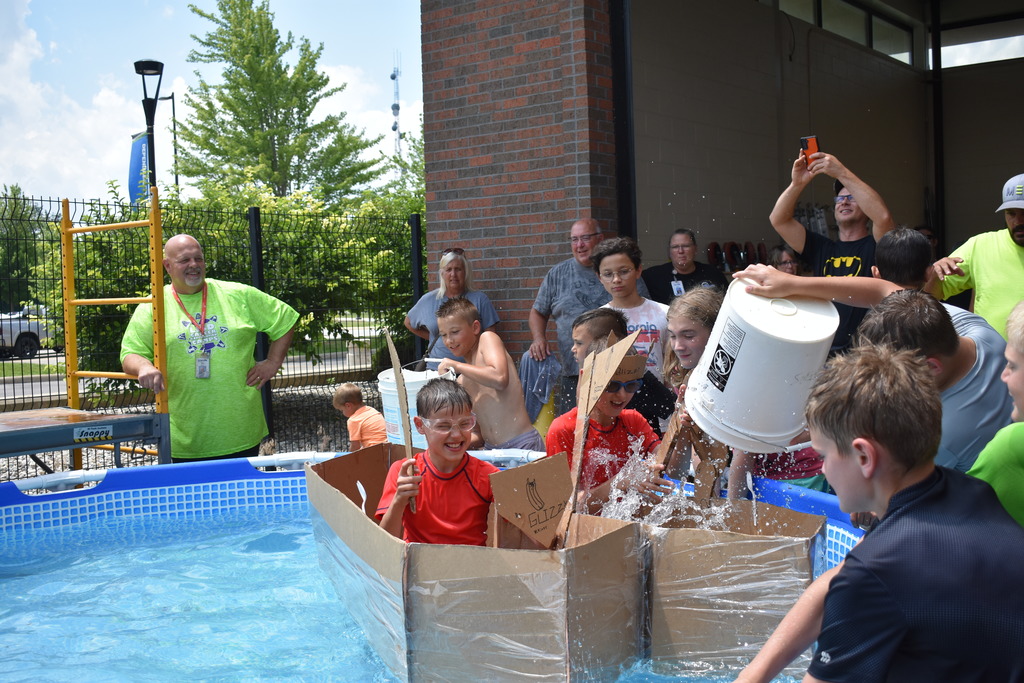 Brothers float in their boat while classmates bring the storm