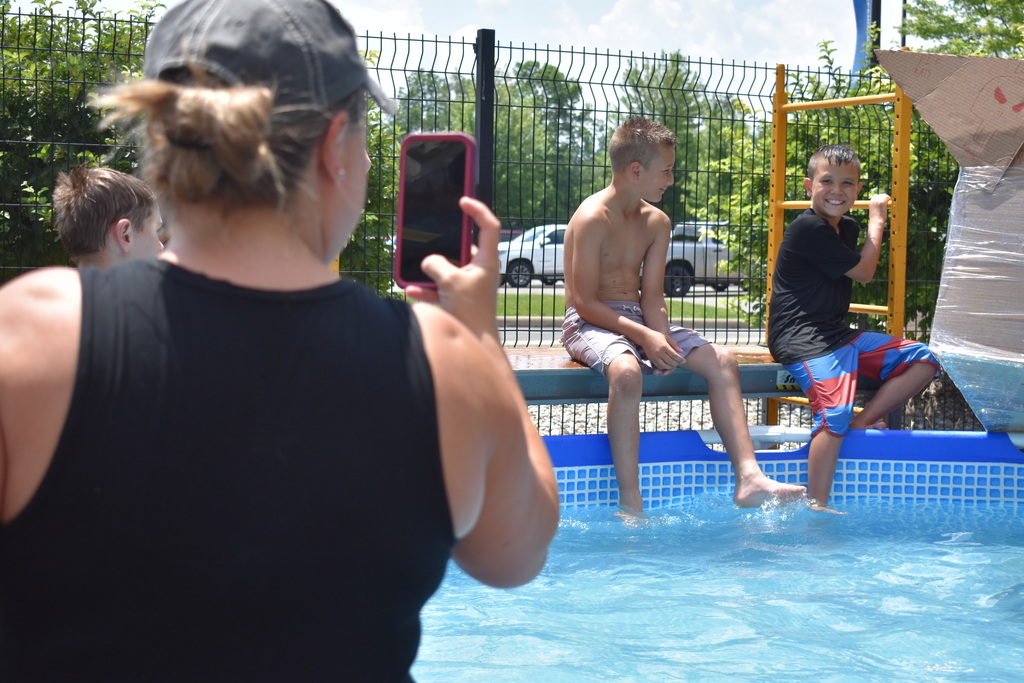 A parent capturing a photo of her kid