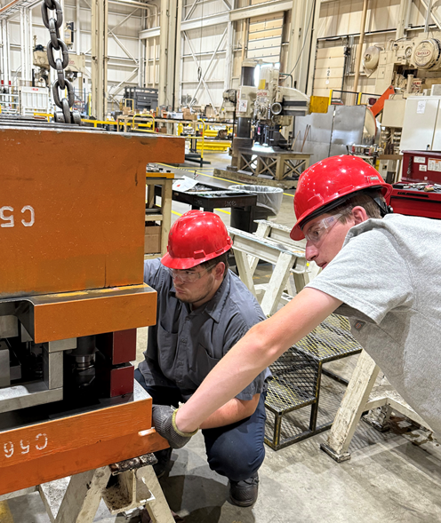 Two alums working together at a local company as apprentices