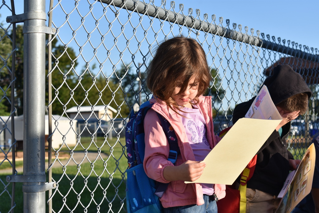 A student reviewing her folder while waiting in line