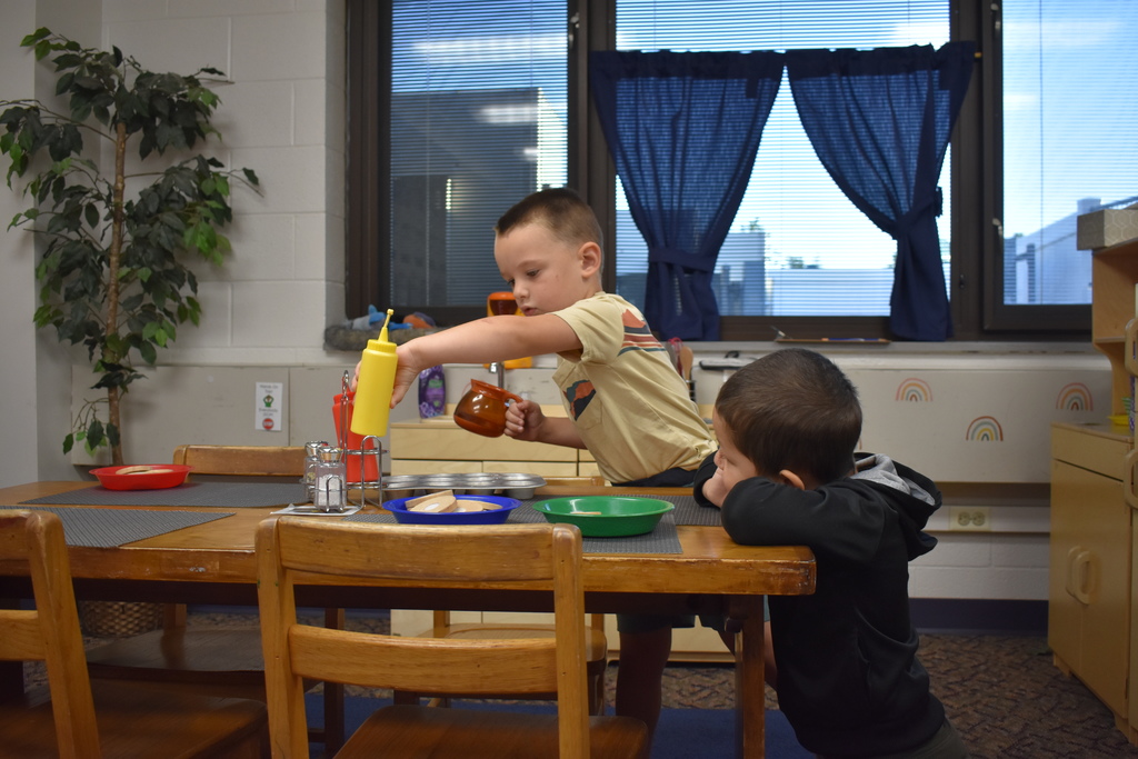 Two children playing with kitchen supplies