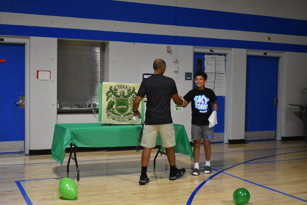 An instructor and student giving each other a high five as they welcome each other to the team