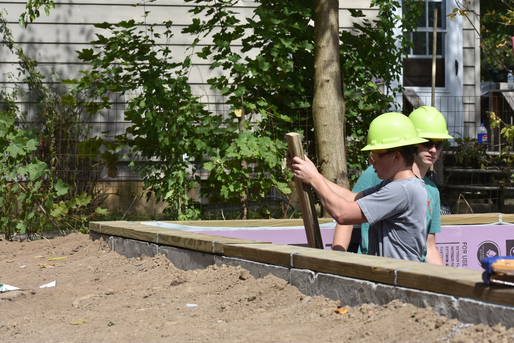 Two students working on getting a wall placed
