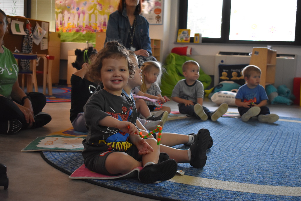 A student smiles at the camera during floor time