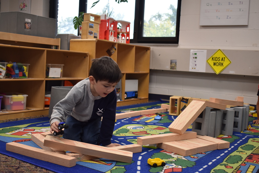 A student builds with blocks a track for his cars