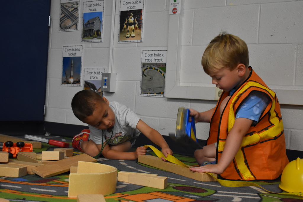 two students play together with building toys