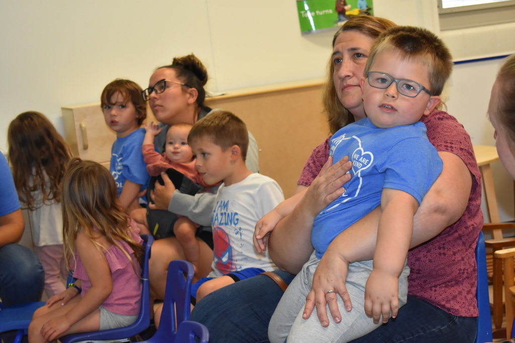 a child sitting on an adult's lamp as he looks at the camera