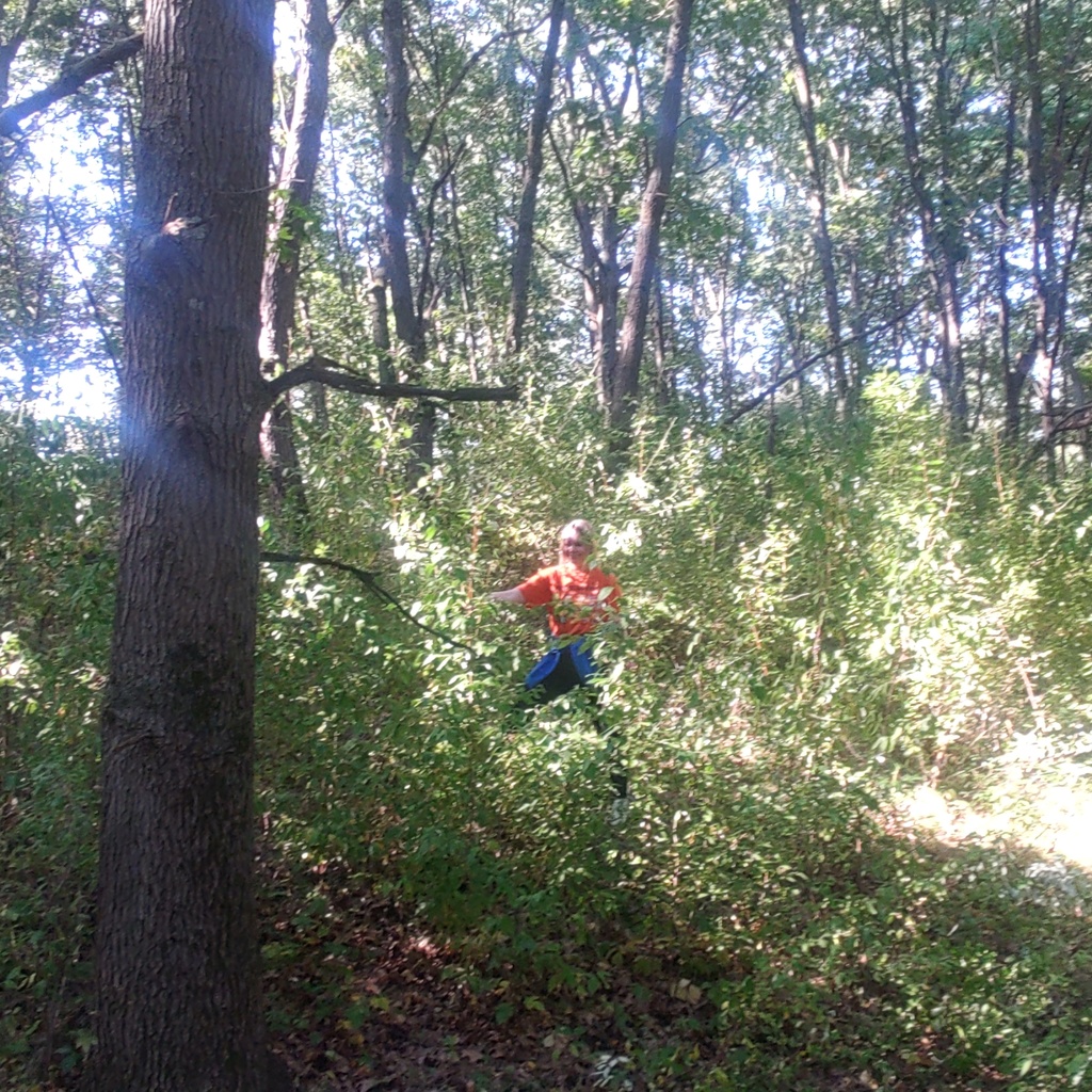 A student in an area with lots of invasive shrubs.