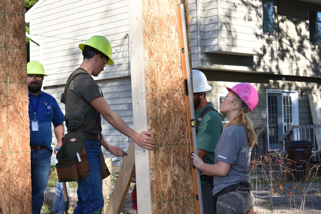two students and two instructors putting up the first wall